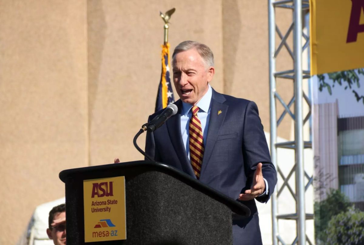 John Giles speaking at an Arizona State University podium on stage